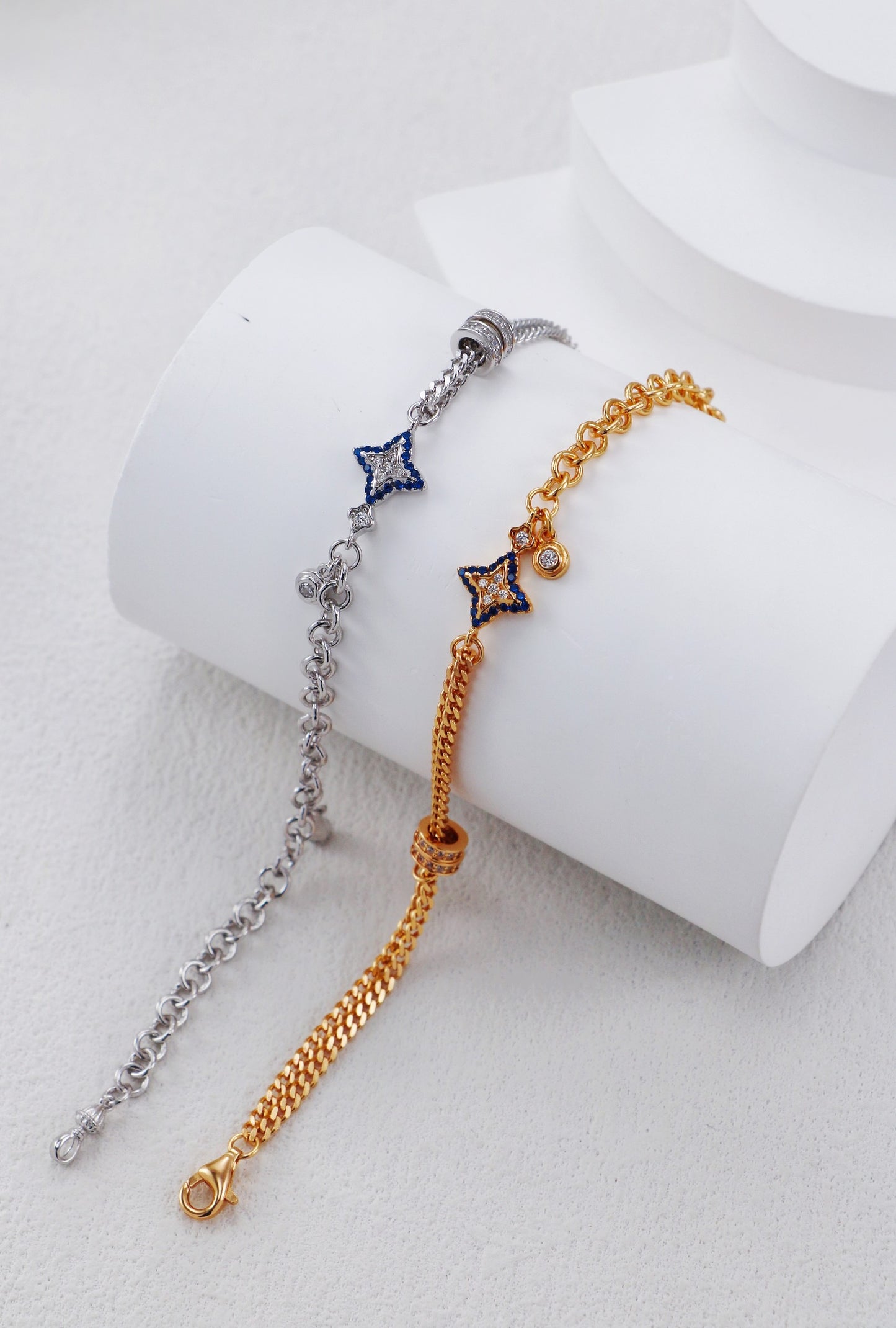 Two star-shaped bracelet options on a white cylindrical stand.