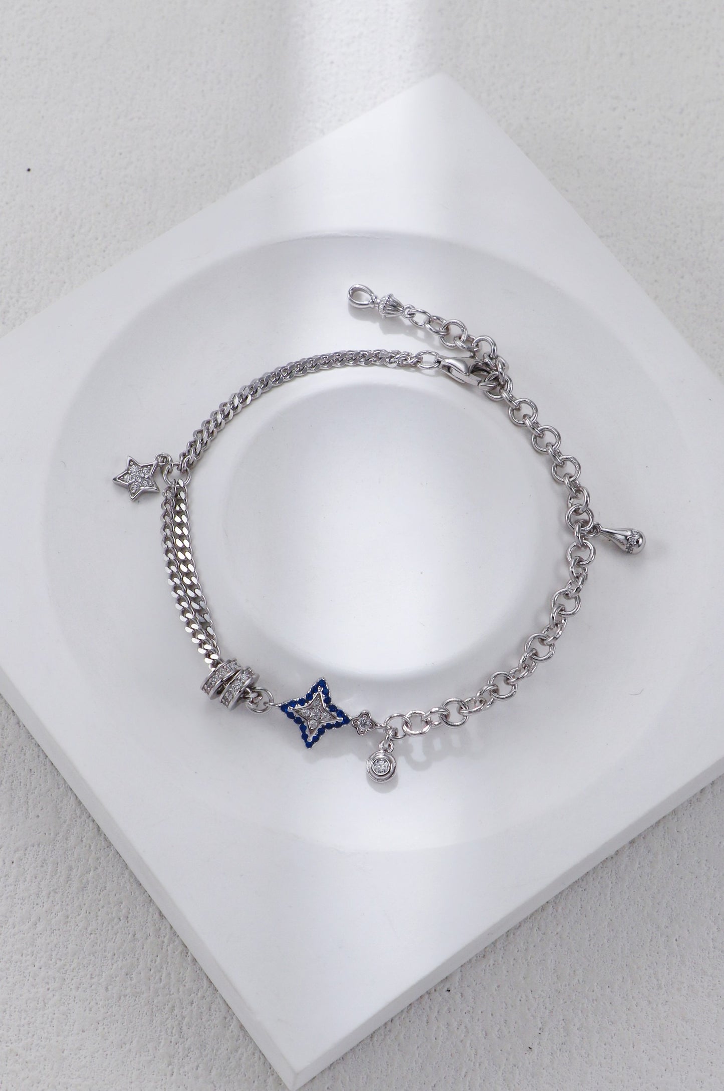 Silver bracelet with star-shaped charm on a white surface