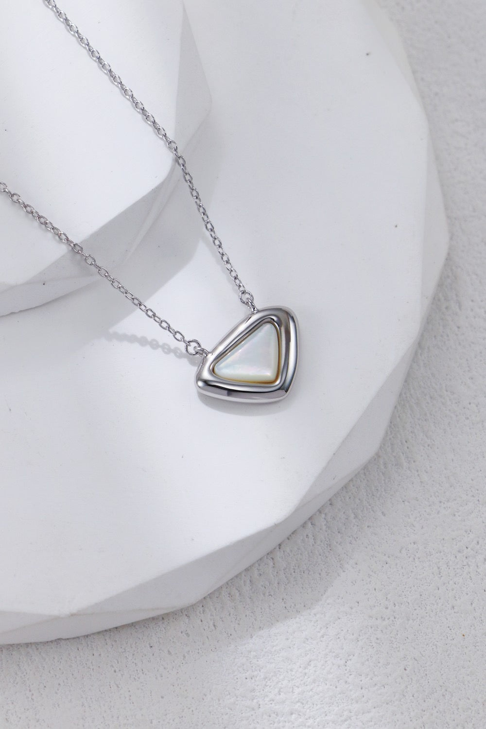 Triangular pendant necklace on a white background