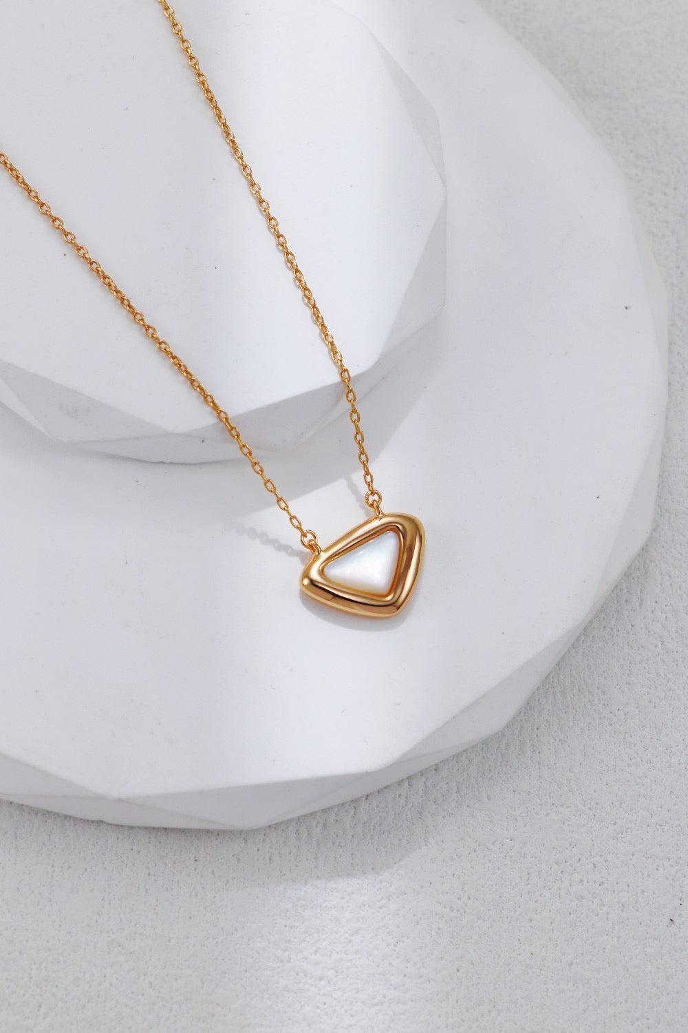 Gold heart-shaped necklace on a white background