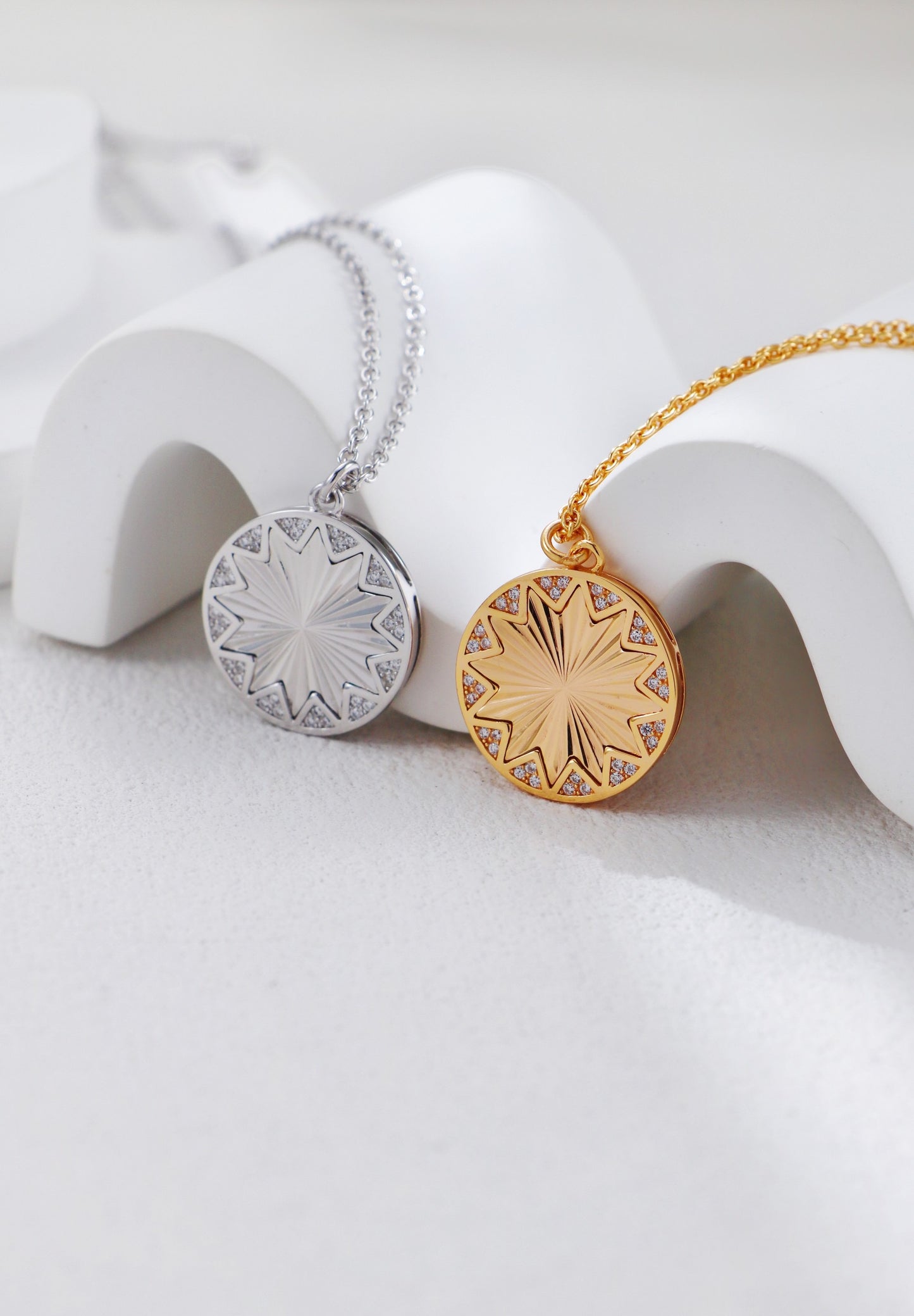 Gold and silver round pendants on white stands