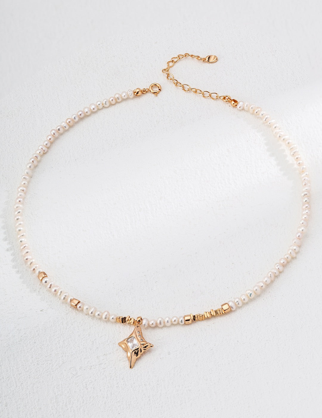 Gold and pearl bracelet on a light gray background