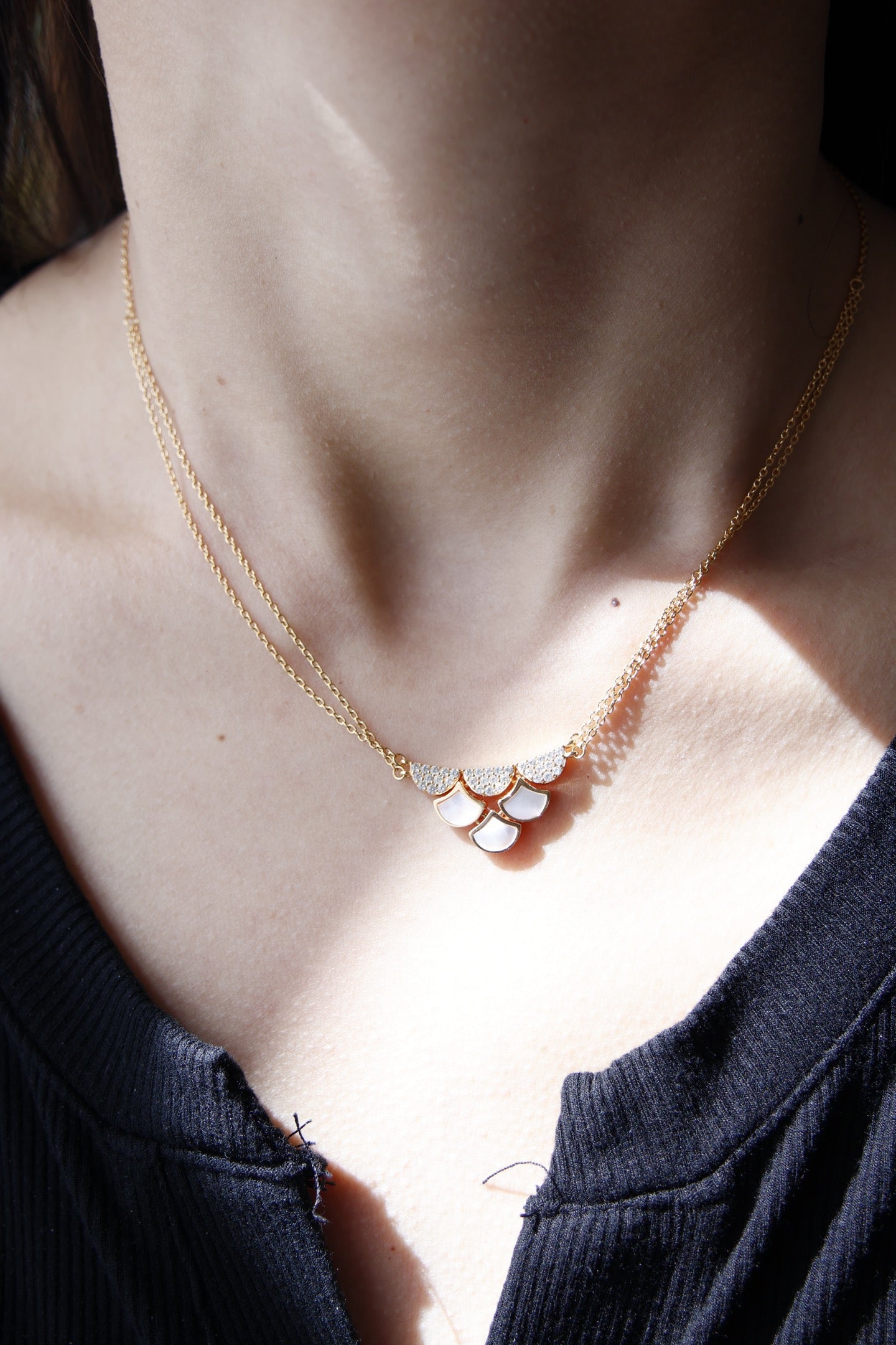 Necklace with a floral pendant worn by a person