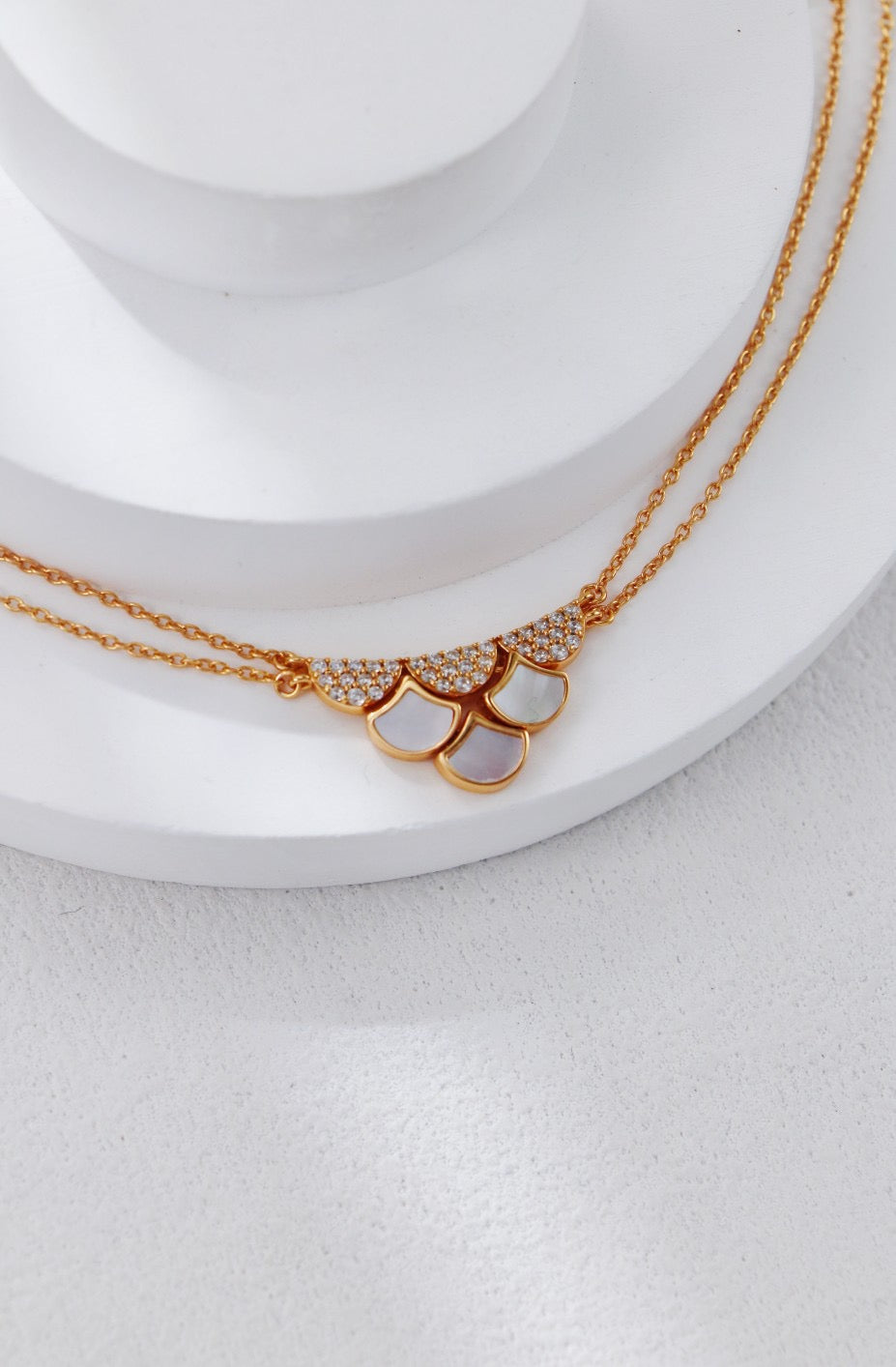 Gold necklaces on a white surface