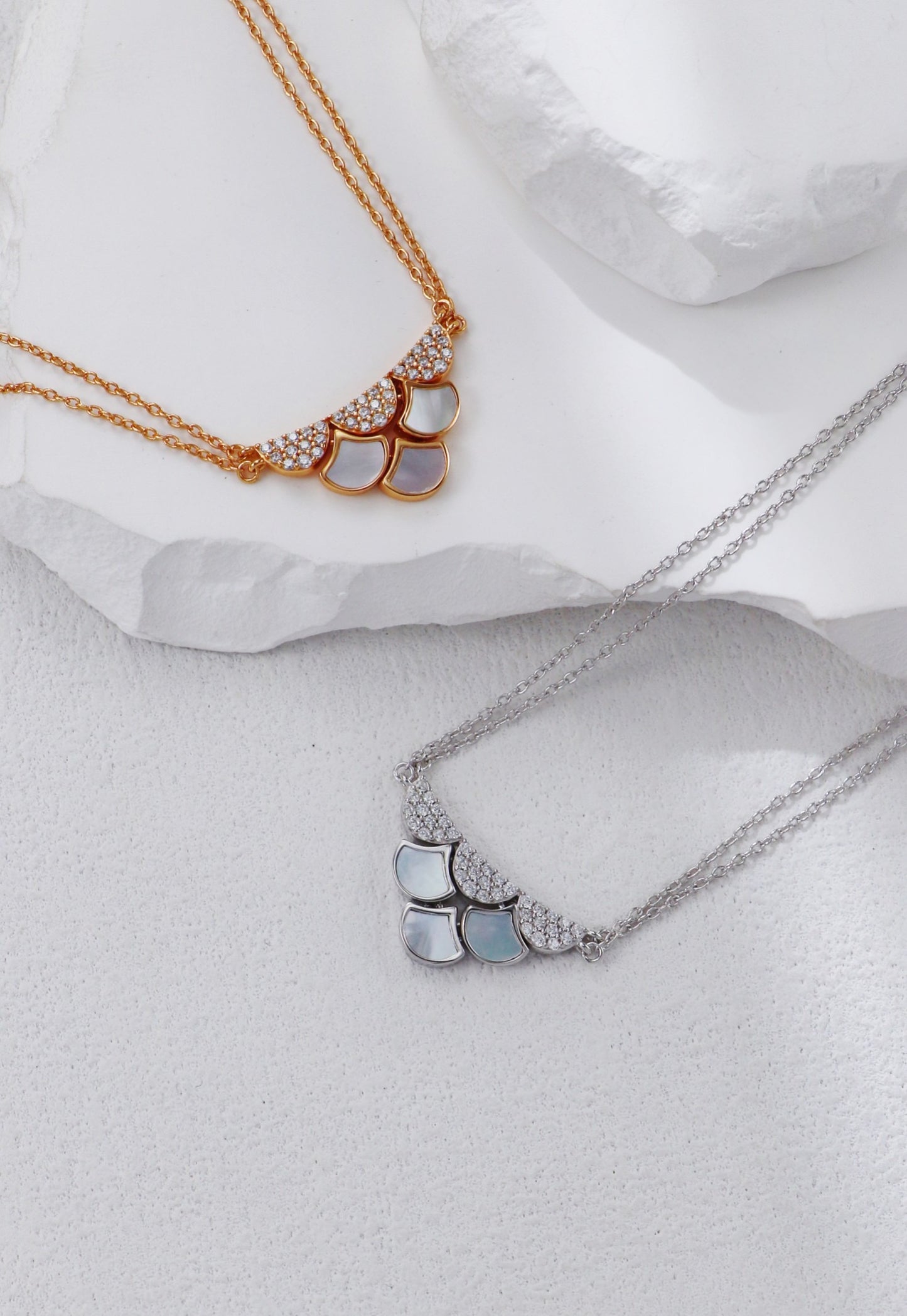 Two necklaces on a white fabric background