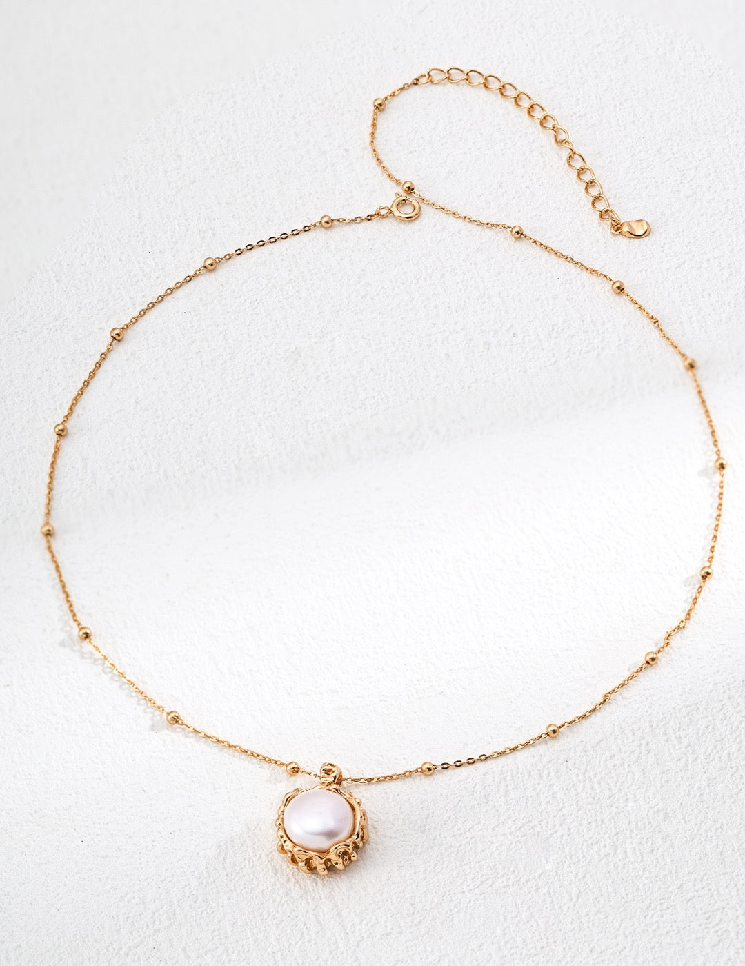 Gold necklace with a pendant on a white background