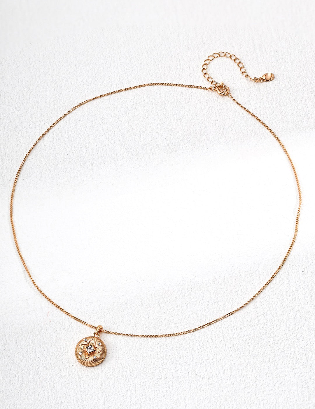 Rose gold necklace with a pendant on a white background