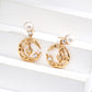 Gold moon and star earrings with pearls on a white surface