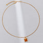 Gold necklace with a square pendant on a white background