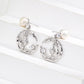 Silver earrings with moon and star designs on a white background