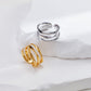Two rings, one gold and one silver, on a white surface.