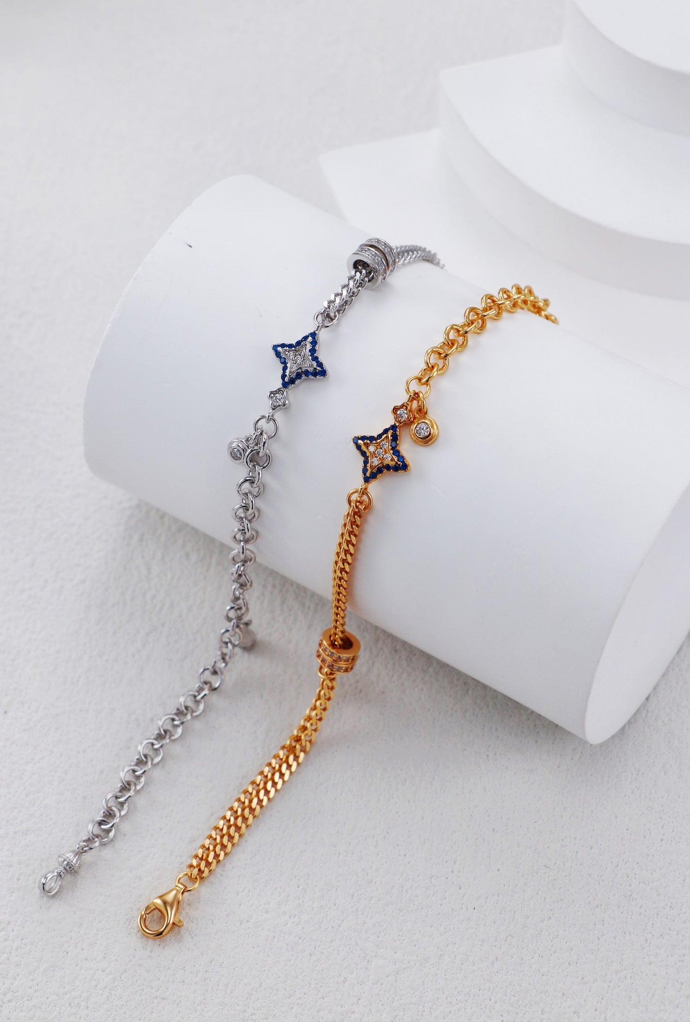 Two star-shaped bracelet options on a white cylindrical stand.
