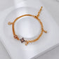 Gold bracelet with star charm on a white surface