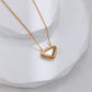 Gold heart-shaped necklace on a white background