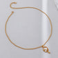 Gold necklace on a light gray background