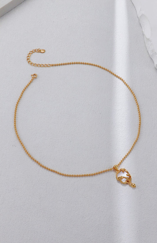 Gold necklace on a light gray background