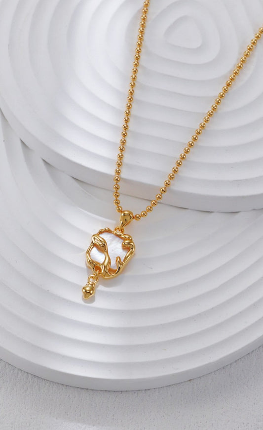 Gold necklace with a cat-shaped pendant on a white background