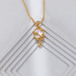 Gold necklace with a small pendant on a textured white surface