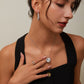 Woman wearing a black dress with jewelry including earrings, a necklace, and rings.