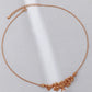Rose gold necklace with floral design on a light gray background
