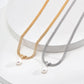 Two pearl necklaces on a white surface, one gold and one silver.