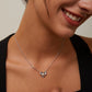 Woman wearing a silver necklace and earrings with a neutral background