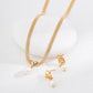 Gold necklace and earrings set on a white background