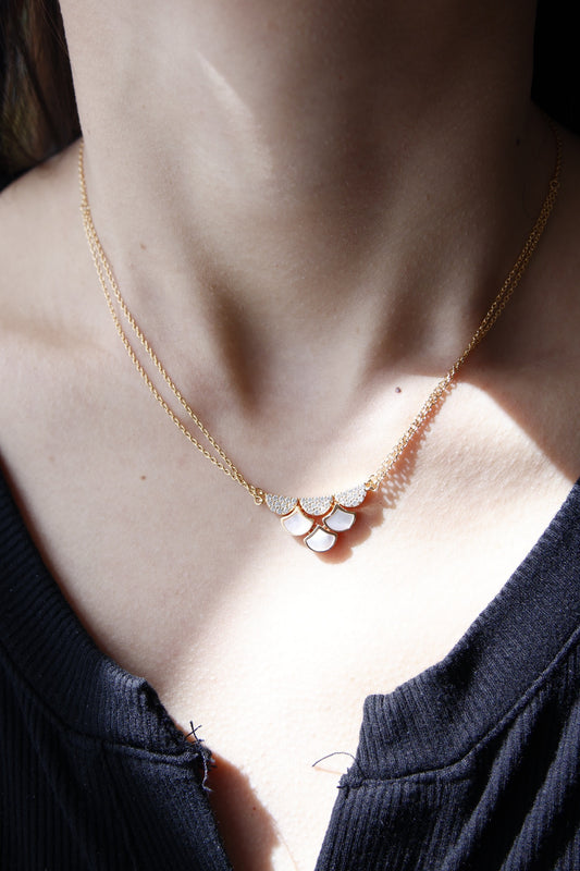 Necklace with a floral pendant worn by a person