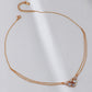 Rose gold necklace with heart-shaped pendants on a white background
