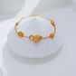 Gold bracelet with a green gemstone on a white mannequin bust.