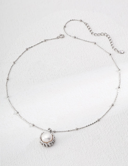 Silver anklet with a pearl charm on a light gray background