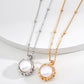 Two pearl necklaces, one gold and one silver, on a white background.