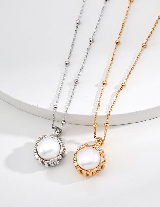 Two pearl necklaces, one gold and one silver, on a white background.