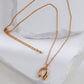 Gold necklace with a horseshoe pendant on a white cushion