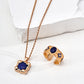 Gold necklace and earrings with blue stones on a white background