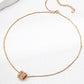 Rose gold necklace with a decorative clasp on a white background
