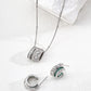 Silver jewelry set with pendant, earrings, and ring on a white surface