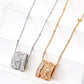 Two necklaces, one silver and one gold, on a white surface.