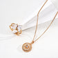 Rose gold necklace with circular pendant and matching ring on a white background