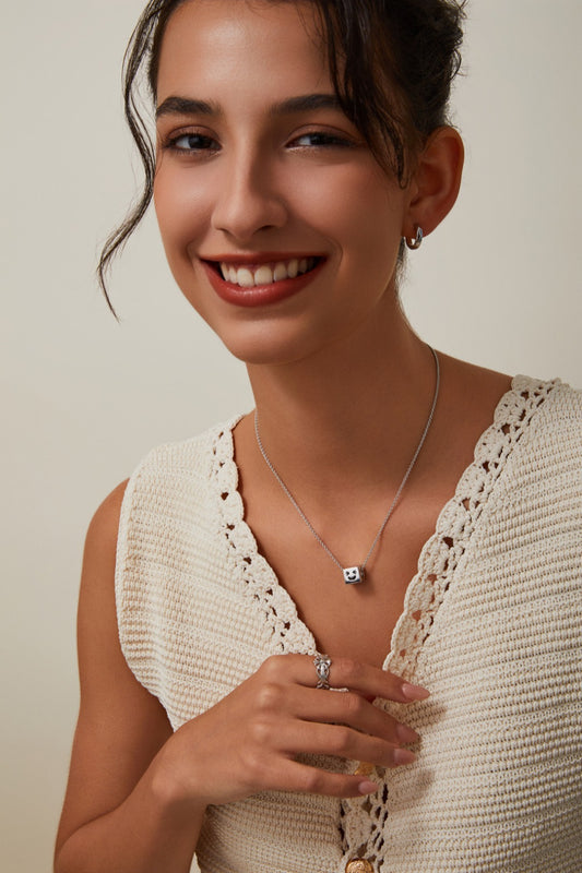 Woman wearing a white crochet top with a neutral background