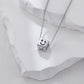 Silver necklace with a cube pendant featuring a smiley face on a white stone background