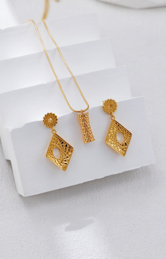 Gold earrings on a white surface