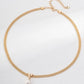 Gold necklace with a pearl pendant on a light gray background
